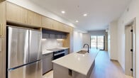 Located at 9999 Elbow Dr in Calgary, AB, this thoughtfully designed one-bedroom, one-bathroom unit offers a modern aesthetic with high-quality finishes throughout. Light hardwood flooring flows seamlessly across the open-concept layout, creating a bright and cohesive atmosphere.

The kitchen is a standout feature, showcasing flat-panel light wood cabinetry that extends to the ceiling for ample storage, stainless steel appliances including a refrigerator and range, a dark tile backsplash, and a generous island with a quartz countertop and undermount sink — ideal for both cooking and casual dining.

The bedroom is a calm, well-proportioned retreat featuring a large black-framed window that frames views of surrounding greenery, allowing abundant natural light to fill the room. Two closets provide practical storage solutions.

The bathroom is finished to a high standard, with large-format white wall tiles, a walk-in shower with a rainfall showerhead, a wood-toned floating vanity with a white quartz countertop, and a full-width mirror. Recessed lighting completes the clean, spa-like feel.

A private balcony with glass railings and a warm wood-panel accent wall extends the living space outdoors, offering elevated views of the Calgary neighbourhood and surrounding tree canopy — perfect for enjoying Alberta's sunny days.