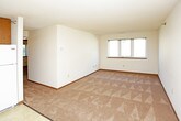 This single-floor unit is designed with a practical, straightforward layout that maximizes functionality across its rooms. The kitchen serves as a central feature, equipped with warm wood-toned cabinetry extending to the ceiling, white appliances including a range, dishwasher, and refrigerator, and a sink set beneath under-cabinet lighting. Light tile flooring defines the kitchen area and transitions seamlessly into the adjacent living space, which is finished with neutral carpet and offers ample room for furnishing arrangements.

Multiple bedrooms are carpeted and finished with cream-toned walls, wood baseboards, and textured ceilings. Each room includes windows fitted with blinds, allowing natural light to filter in while providing privacy. Views from the windows vary, with some overlooking mature trees and greenery, adding a pleasant outdoor connection. Electrical outlets are positioned throughout each room for practical use.

The unit includes two bathrooms. One features a full tub-shower combination, toilet, and a wood-cabinet vanity with tile flooring. The second bathroom offers a vanity with a wall-mounted mirror and lighted fixture, along with a toilet. Both are clean and functional in design. Closet space is also present within the unit, contributing to overall storage capacity.