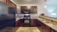 Located at 3914 E Brewster St in Sioux Falls, South Dakota, this single-floor home offers a thoughtfully designed layout with consistent finishes and practical living spaces throughout. The kitchen serves as a functional hub, featuring rich dark-stained cabinetry, light countertops, wood-look flooring, and a full suite of black appliances including a refrigerator, electric range, and over-the-range microwave. Ample upper and lower cabinet storage is complemented by convenient access to an adjacent laundry area housing a washer and dryer.

The bedrooms are carpeted and well-sized, each benefiting from natural light provided by windows with blinds. The primary bedroom includes a spacious walk-in style closet with built-in shelving, while additional bedrooms offer generous proportions suitable for various uses. A dedicated office or flex room features carpet flooring and a bright window, making it ideal for working from home or study.

Both bathrooms maintain a cohesive aesthetic with dark wood vanities, light countertops, single-basin sinks, and wood-look flooring. One bathroom includes a walk-in shower, while the other provides a full vanity setup. The overall ambiance of the home is clean, neutral, and move-in ready, with a consistent design language tying each room together.