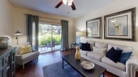 Located in Tampa's 33603 zip code, this single-floor residence offers a thoughtfully designed layout with warm, cohesive interiors throughout. Rich hardwood flooring runs continuously across the main living areas, creating a sense of flow and visual warmth.

The open living and dining area forms the heart of the home. The living room features a ceiling fan, sliding glass doors that open to a private outdoor patio overlooking lush greenery, and built-in shelving that adds functional character near the entry. The dining area is defined by a pendant light fixture and is sized comfortably for a full dining table set.

The kitchen is efficiently laid out with white cabinetry, a window above the sink for natural light, and black appliances including a refrigerator, range, and dishwasher. Generous counter and cabinet space make it a practical workspace.

Two well-proportioned bedrooms each include ceiling fans, hardwood floors, and closet access. The rooms are bathed in natural light and offer a calm, restful atmosphere.

Two bathrooms serve the home, each featuring white vanity cabinetry, a single sink, and a tub-shower combination. Clean, neutral finishes give both bathrooms a bright and functional character. Overall, the residence presents a comfortable, well-maintained living environment with easy access to the surrounding Tampa community.