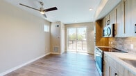 Located at 5847 Arapahoe Avenue in Boulder, Colorado, this efficiently designed single-floor unit offers a thoughtful layout across a compact footprint. The space comprises an entrance, a full kitchen, and a bathroom, all finished to a contemporary standard that maximizes both function and style.

The kitchen is a standout feature, showcasing floor-to-ceiling light wood cabinetry with matte black hardware that provides generous storage. Stainless steel appliances — including a range, over-the-range microwave, dishwasher, and refrigerator — are complemented by white quartz countertops and a warm stone tile backsplash, creating a cohesive and modern aesthetic.

The open living area is bright and airy, bathed in natural light from a large sliding glass door that leads to an outdoor space, as well as a high transom window. Light hardwood flooring runs throughout, contributing to a clean, modern feel, while a ceiling fan adds comfort and a sense of height to the room.

The bathroom is well-appointed with warm-toned tile flooring, a wood vanity with a white countertop, matte black fixtures, a framed mirror, and a glass-enclosed shower, maintaining the consistent design language found throughout the unit. Together, these elements create a stylish and highly functional living space.
