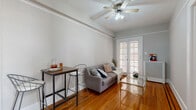 Located at 2505 13th St NW in Washington, DC's vibrant Columbia Heights neighborhood, this 2-bedroom, 1-bathroom unit offers a well-organized and functional layout across a single floor. Warm hardwood floors run throughout the living areas and bedrooms, lending a classic, cohesive feel to the entire space.

The living room is bright and inviting, featuring crown molding, a ceiling fan with light fixture, and elegant French doors that allow natural light to fill the room. The space accommodates both a seating area and a compact dining setup, making efficient use of the available square footage.

The kitchen is equipped with dark wood cabinetry, granite-style countertops, a stainless steel sink, and white appliances including a gas range and dishwasher. A window above the counter brings in additional natural light.

The primary bedroom is a comfortable, well-proportioned room with multiple windows offering natural light and views of the surroundings, along with closet access. The second bedroom also features hardwood floors, a window, and generous wall space. Both bedrooms include radiator heating units.

The bathroom is clean and bright, finished in white with a vanity, tub-shower combination, tiled flooring, and a window for ventilation. Two hallways and two closets round out the layout, providing practical storage and connectivity throughout the unit.