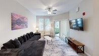 This thoughtfully designed one-bedroom, one-bathroom unit at 4550 Sleepy Way, Unit 106, offers a clean, modern aesthetic throughout its efficiently planned single-level layout. The open-concept kitchen and living area forms the heart of the home, with the kitchen showcasing bright white shaker cabinetry, light granite countertops, a classic subway tile backsplash, and a full suite of stainless steel appliances including a range, microwave, dishwasher, and refrigerator. Track lighting and wood-look plank flooring complete the kitchen's polished look. The living room flows naturally from the kitchen and dining area, featuring a ceiling fan, large sliding glass door that invites natural light and outdoor access, and ample space for comfortable seating. The generously sized bedroom is carpeted for warmth and comfort, fitted with a ceiling fan, natural light from dual windows, and a walk-in closet with built-in shelving. The full bathroom features a tub-shower combination with clean white tile surround and wood-look flooring. Throughout the unit, a neutral gray-and-white color palette creates a bright, cohesive, and welcoming ambiance ideal for everyday living.