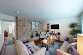 This single-story, one-bedroom, one-bathroom unit offers a smart and efficient layout across a compact yet comfortable floor plan. The living room serves as the heart of the space, featuring rich hardwood-style flooring, a large window with blinds that invites natural light, and an exposed brick accent wall that adds a distinct architectural character to the room. The adjacent dining area continues the warm hardwood flooring and includes a ceiling fan with light fixture, creating an intimate yet functional space for everyday meals. The galley-style kitchen is well-equipped with warm wood cabinetry, a double-basin sink, and black appliances including a refrigerator and range, all complemented by wood-style flooring. The spacious bedroom is carpeted for comfort, featuring a ceiling fan, a large window for natural light, and direct access to a dedicated closet. The bathroom is clean and functional, offering a tiled tub-shower combination with a curtain rod, hardwood-style flooring, and a vanity with countertop sink. Hallways connect the rooms efficiently, and a closet provides additional storage. Throughout the unit, neutral wall tones and consistent finishes create a cohesive and welcoming ambiance.