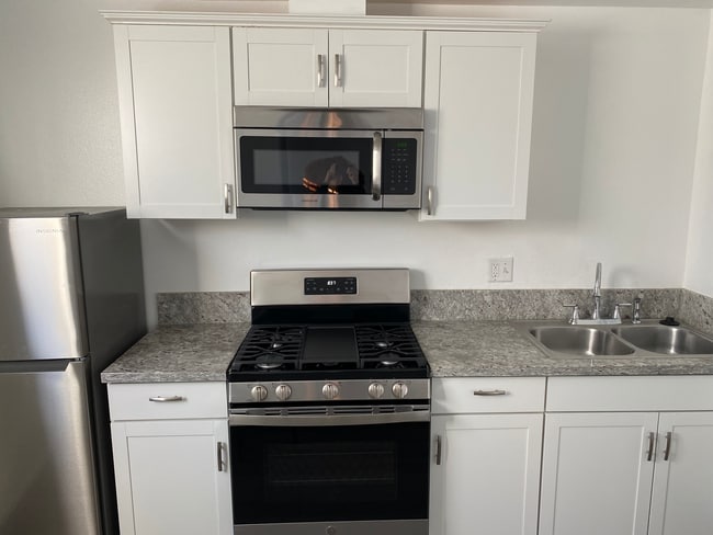 Studio kitchen features granite counter tops, full gas range, microwave, and fridge. - 1911 W 94th St House