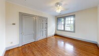 Located at 724 29th St S in Birmingham, Alabama, this single-floor home offers four bedrooms, one kitchen, and one full bathroom within a compact yet efficiently arranged layout. Warm hardwood flooring runs throughout the bedrooms and common areas, lending a sense of continuity and classic character to the interior. The rooms are finished with crisp white walls, gray-trimmed doors, and ceiling fans in several bedrooms, contributing to a clean, understated aesthetic. Natural light filters in through windows fitted with horizontal blinds, offering views of the surrounding neighborhood. The spacious primary bedroom provides ample room and connects easily to the rest of the home through paneled gray interior doors. Additional bedrooms are modest in size but well-proportioned, each sharing the same consistent hardwood flooring and neutral palette. The bathroom features classic white penny tile flooring, a pedestal sink, a mirrored medicine cabinet, and a tub-shower combination, maintaining a vintage functional style. The kitchen is equipped with a gas range, stainless steel sink, gray upper cabinetry, and a window above the counter, brightening the workspace. A bold black-and-white checkered floor tile adds a retro touch to this practical cooking area.