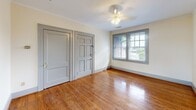 Located at 724 29th St S in Birmingham, Alabama, this single-story home offers four bedrooms, one bathroom, and a kitchen within a compact yet efficiently arranged floor plan. The home showcases classic architectural character, highlighted by warm hardwood floors that run throughout the living areas and bedrooms, complementing the neutral, light-toned walls. A standout architectural feature is the elegant arched doorway connecting the main living area to an adjoining room, adding a timeless charm to the interior. The spacious primary bedroom benefits from ample natural light and a ceiling fan overhead. Additional bedrooms are well-proportioned, each featuring hardwood flooring, ceiling fans, and windows that bring in natural light and outdoor views of the surrounding neighborhood. The kitchen is functional and compact, featuring a gas range, stainless steel sink, gray upper cabinetry, a window for natural light, and a classic black-and-white checkerboard tile floor. The bathroom retains its vintage character with penny-round mosaic tile flooring, a pedestal sink, a medicine cabinet, and a shower-tub combination. Gray-painted door and window trim provide a cohesive, updated accent throughout the home.