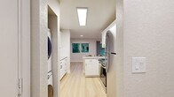Located at 14274 SE 6th St in Bellevue, WA, this thoughtfully updated 2-bedroom, 2-bathroom residence offers a well-designed single-floor layout that maximizes every square foot. Light-toned hardwood-style flooring flows seamlessly throughout, lending a clean, cohesive aesthetic to the entire space.

The open-concept living area is anchored by a modern tile-surround fireplace and is bathed in natural light, with recessed lighting overhead for added warmth in the evenings. The kitchen is a functional highlight, featuring crisp white shaker cabinetry, quartz countertops, a tile backsplash, stainless steel appliances including a refrigerator, range, microwave, and dishwasher, and a peninsula that opens to the living space. A stacked washer and dryer unit is conveniently tucked within the layout.

Both bedrooms are well-proportioned and finished with neutral tones and large windows that invite natural light and views of the surrounding lush greenery. The primary bedroom benefits from sliding glass doors that open directly to an outdoor deck surrounded by verdant foliage. Each bathroom is cleanly appointed with white tub-shower combinations, undermount sinks, and matte black fixtures that add a contemporary touch. A hallway connects the rooms, keeping the layout efficient and accessible.