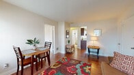 This single-floor home in Louisville, Kentucky, offers a comfortable and functional layout with a warm, inviting ambiance throughout. The living area is bright and airy, featuring rich hardwood flooring and multiple windows that allow natural light to fill the space. A colorful area rug anchors the room, adding a vibrant touch to the neutral palette of the walls and trim. The living space flows naturally into a dedicated dining area, creating a cohesive open feel ideal for everyday living and entertaining.

The kitchen is well-equipped and efficiently designed in a U-shaped layout, showcasing rich dark wood cabinetry, neutral countertops, and a full suite of appliances including an electric range and dishwasher. A window above the sink brings in natural light, enhancing the functional workspace.

The home includes multiple bedrooms, each carpeted for comfort and fitted with windows dressed in horizontal blinds that provide both privacy and natural light. Ceiling fans with light fixtures are present in the bedrooms, adding to the practical design.

The bathroom is cleanly finished with classic white tile, a tiled tub-shower combination, and a window that provides ventilation and light. The entry area transitions smoothly into the main living space, completing this practical and cozy Louisville home.
