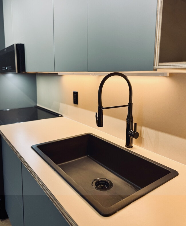 ¡Nuevo! Apartamento Premium Plus de 2 habitaciones y 1 baño, 800 pies cuadrados, disponible a partir del 6 de abril. Cocina moderna y elegante con fregadero negro y gabinetes modernos que crean un ambiente contemporáneo. - Piccadilly East