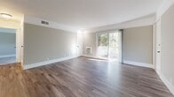 Located at 200 Coggins Dr in Pleasant Hill, CA, this 2-bedroom, 1-bathroom residence offers a well-designed single-floor layout with a cohesive, neutral color palette throughout. The spacious living area features rich hardwood-style flooring, soft gray walls, and clean white baseboards, creating a bright and inviting atmosphere. A sliding glass door connects the living room to a private balcony, filling the space with natural light and offering pleasant views of the surrounding greenery.

The combined kitchen and dining area is thoughtfully appointed with white cabinetry, granite-style countertops, stainless steel appliances, and a pendant chandelier above the dining space. A window above the sink brings in additional natural light, enhancing the functional yet stylish design.

Both bedrooms are carpeted for comfort and feature large windows that frame views of mature trees. The primary bedroom offers generous proportions and ample closet space with sliding panel doors. The full bathroom is finished with a white subway-tiled tub and shower combo, a granite-topped vanity, and wood-style flooring for a clean, modern look.

Additional highlights include multiple closets for storage, a dedicated laundry area, and a utility room, making this residence as practical as it is comfortable.