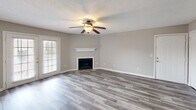 Located at 350 Byram Dr in Byram, MS, this single-story, 3-bedroom, 3-bathroom home offers a practical and well-designed layout across a comfortable footprint. The living room serves as the heart of the home, featuring a classic fireplace with a white mantel, a ceiling fan with integrated lighting, and wood-look luxury vinyl plank flooring. A large green-framed glass door floods the space with natural light and provides outdoor access. The kitchen is designed for functionality, featuring a peninsula with a marble-style countertop, white cabinetry with natural wood accents, a stainless steel sink, and black appliances including a refrigerator, range, and microwave. A skylight brightens the kitchen interior. The bedrooms are carpeted for comfort, each offering ceiling fans and ample natural light from windows. The spacious primary bedroom provides generous room with two access doors. The bathrooms are well-appointed with marble-look vanity countertops, wood-toned cabinetry, large mirrors, and clean white tub-shower combinations. Wood-look flooring continues through the bathrooms and hallway, tying the home together with a cohesive, modern aesthetic throughout.