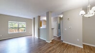Located at 6810 Valley Ridge Dr in Indianapolis, IN, this single-floor, 2-bedroom, 2-bathroom home offers a comfortable and cohesive layout designed for easy living. Rich wood-style flooring flows consistently throughout the space, complementing the neutral, warm-toned walls that create a bright and welcoming ambiance.

The open-concept living area connects seamlessly to the dining room and kitchen, with structural columns adding architectural interest. The dining area is highlighted by an elegant brushed-nickel chandelier, while the living room benefits from natural light through large windows overlooking a private outdoor setting. The kitchen features warm honey-toned cabinetry, generous counter space with speckled gray countertops, a double-basin sink, and a white range, with views through to the dining and living areas.

The primary bedroom is a spacious retreat with a dedicated en-suite bathroom showcasing warm wood vanity cabinetry and a well-lit mirror, plus an adjacent closet. The second bedroom also enjoys natural light from a large window with outdoor views. Both bathrooms are finished with tiled tub-shower combinations, wood-tone vanities, and matching gray countertops. Three closets throughout the home provide ample storage, completing this practical and inviting residence.