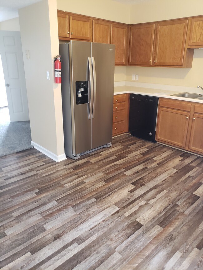 Kitchen with new flooring new refrigerator with freezer and icemaker.and a dishwasher. - 3212 Spring Hollow Ave