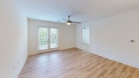 Located at 803 Holliday Dr in Greensboro, NC, this 2-bedroom, 3-bathroom residence offers a clean, modern aesthetic throughout. Light wood-look flooring flows seamlessly across every room, complementing the crisp white walls and creating a bright, cohesive feel. The open kitchen-living area serves as the heart of the home, featuring a well-equipped kitchen with white shaker cabinetry, granite countertops, stainless steel appliances including a refrigerator, range, and built-in microwave, and recessed lighting overhead. The living room is fitted with a ceiling fan and French doors that invite natural light and provide access to an outdoor balcony with leafy views. Both bedrooms are comfortably sized, each equipped with ceiling fans and windows that frame the surrounding greenery. The primary bedroom includes its own dedicated bathroom. The bathrooms are finished with clean white walk-in showers featuring built-in shelving, as well as vanities topped with granite countertops, white cabinetry, and brushed nickel fixtures. A closet and hallway round out the layout, offering practical storage. The overall ambiance is light, fresh, and move-in ready, with consistent modern finishes throughout.