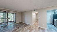 Located at 600 S Churton St in Hillsborough, North Carolina, this single-floor residence offers a clean, neutral aesthetic throughout. The main living area features light-toned wood-look luxury vinyl plank flooring, warm greige walls, crown molding, and a textured ceiling, lending a polished yet approachable feel. A sliding glass door connects the living space to an outdoor area, allowing natural light to flow freely into the room. An adjacent area with a skylight and built-in closet provides versatile additional living space. The galley-style kitchen is well-appointed with gray cabinetry, light countertops, and a full suite of stainless steel appliances including a refrigerator, electric range, and over-the-range microwave, all set atop coordinating wood-look flooring. Bedrooms are finished with plush wall-to-wall carpeting and feature generous closet storage, including one room with dual sliding-door closets offering abundant hanging and shelving space. Natural light reaches the bedrooms through windows dressed with horizontal blinds. The unit's consistent neutral color palette, updated finishes, and thoughtful layout create a comfortable, move-in-ready living environment in the heart of Hillsborough.