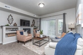 Located at 4595 Stamm Ln in Nampa, Idaho, this well-appointed single-floor residence offers a thoughtfully designed layout that balances comfort and functionality. The living room serves as the heart of the home, centered around a tiled fireplace with a built-in media shelf and mantle. Sliding glass doors lead to an outdoor patio, filling the space with natural light and providing easy access to the exterior. Plush carpeting runs throughout the living areas and bedrooms, adding warmth underfoot. The dining area is a defined space, illuminated by an overhead chandelier and offering room for a full dining set. The kitchen features white shaker-style cabinetry, granite-look countertops, and a full suite of stainless steel appliances, including a refrigerator, range, and over-the-range microwave, complemented by wood-look vinyl flooring. The primary bedroom offers natural light through multiple windows and comfortable carpeted flooring. A second bedroom provides additional accommodation with a closet and its own window. Both bathrooms are well-finished, featuring tub-shower combinations, white vanity cabinetry, granite-look countertops, and wood-look vinyl flooring. A central hallway connects the bedrooms and bathrooms, creating an efficient and cohesive flow throughout the home.