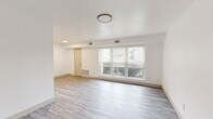 Located at 1301 Canal Dr in Chesapeake, Virginia, this single-floor, three-bedroom, one-bathroom home offers a clean and functional layout designed for comfortable everyday living. The main living area greets you at entry with durable light-toned luxury vinyl plank flooring and a bank of large windows fitted with blinds, allowing ample natural light and views of the surrounding neighborhood. The galley-style kitchen is a standout feature, showcasing white shaker cabinetry, granite-look countertops, a stainless steel sink, and black appliances including a refrigerator, electric range with microwave, and dishwasher. Light-toned LVP flooring continues throughout the kitchen, maintaining a cohesive aesthetic. The three bedrooms are carpeted and finished in bright white, each featuring windows with blinds that invite natural light. The generously sized primary bedroom includes direct access to a dedicated walk-in closet equipped with built-in shelving and hanging rods. The full bathroom is finished in crisp white, featuring a tub-shower combo with built-in shelving, a vanity with mirror, and updated light fixtures. Throughout the home, white walls, clean trim, and consistent finishes create a bright, move-in-ready atmosphere.