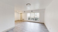 Located at 1301 Canal Dr in Chesapeake, Virginia, this single-floor, three-bedroom, one-bathroom home offers a clean and functional layout designed for comfortable everyday living. The main living area greets you at entry with durable light-toned luxury vinyl plank flooring and a bank of large windows fitted with blinds, allowing ample natural light and views of the surrounding neighborhood. The galley-style kitchen is a standout feature, showcasing white shaker cabinetry, granite-look countertops, a stainless steel sink, and black appliances including a refrigerator, electric range with microwave, and dishwasher. Light-toned LVP flooring continues throughout the kitchen, maintaining a cohesive aesthetic. The three bedrooms are carpeted and finished in bright white, each featuring windows with blinds that invite natural light. The generously sized primary bedroom includes direct access to a dedicated walk-in closet equipped with built-in shelving and hanging rods. The full bathroom is finished in crisp white, featuring a tub-shower combo with built-in shelving, a vanity with mirror, and updated light fixtures. Throughout the home, white walls, clean trim, and consistent finishes create a bright, move-in-ready atmosphere.