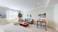 Located at 7027 Park Mill Drive in Plain City, Ohio, this two-story home offers a well-designed layout across two floors. The main level features an open-concept kitchen and living area with warm hardwood-style flooring. The kitchen is appointed with dark cabinetry, granite countertops, stainless steel appliances, and a central island with pendant lighting and bar seating — ideal for both cooking and casual dining. The adjacent living and dining area is bright and welcoming, featuring plush carpet, crown molding, and natural light from large windows. A convenient half bath with a pedestal sink is also located on the main floor. Upstairs, the primary bedroom offers a comfortable, light-filled retreat with vaulted ceilings, a ceiling fan, and a walk-in closet with built-in shelving. A second well-sized bedroom provides additional flexibility. Two full bathrooms serve the upper level, including one with a glass-enclosed walk-in shower and granite vanity. The home also includes an attached garage, a dedicated laundry area, a utility room, and multiple closets for ample storage. The overall aesthetic is clean, modern, and move-in ready.