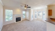 This single-floor residence offers a functional and comfortable layout with a variety of well-designed living spaces. The spacious living room serves as the heart of the home, featuring a tile-surround fireplace, plush carpeting, crown molding, a ceiling fan with light kit, and multiple windows with blinds that allow natural light to fill the room. A charming bay window area adds architectural interest and additional brightness to the space.

The kitchen is equipped with warm oak cabinetry, laminate countertops, and white appliances including a range, over-the-range microwave, and refrigerator. Tile flooring and a stainless steel sink complete the functional cooking space, which opens to an adjacent dining or living area through an arched passageway, reinforcing the open flow of the floor plan.

The bedrooms are generously sized, each featuring soft carpeting, ceiling fans, and windows that bring in natural light. At least one bedroom includes access to a walk-in closet, adding practical storage. The bathrooms are finished with wood-look tile flooring, oak cabinetry, and tiled tub-shower combinations with chrome fixtures, offering clean and efficient design. Overall, the residence presents a bright, neutral palette throughout with consistent finishes that create a cohesive living environment.