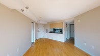 This single-floor residence offers a practical and comfortable layout designed to maximize both space and functionality. The open-concept living and dining area is finished with warm light wood hardwood flooring that extends throughout the main living spaces, creating a bright and cohesive atmosphere. A large sliding glass door leads to a private balcony, allowing natural light to flood the interior and providing outdoor views of surrounding greenery.

The kitchen is accessible via a pass-through counter with a dark laminate countertop, offering a convenient connection to the living area. Light maple cabinetry above the pass-through provides ample storage, while the kitchen itself is equipped with a range, microwave, refrigerator, and a stainless steel sink.

The unit includes two bedrooms, both carpeted in neutral tones and featuring windows that bring in natural light and outdoor views. Each bedroom is well-proportioned with dedicated closet space. Two full bathrooms serve the residence, each featuring tile flooring, a tub-shower combination, a white vanity with under-sink storage, and a large mirror above the sink. The layout is thoughtfully organized, with each area of the home clearly defined while maintaining an open and connected feel throughout.
