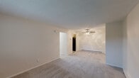 Located at 2 Hidden Valley Dr in Toledo, Ohio, this 2-bedroom, 1-bathroom unit offers a practical and well-organized single-floor layout. The living room serves as the central gathering space, featuring neutral-toned carpet, a ceiling fan with light fixture, baseboard heating, and a textured ceiling. An open passage connects the living area to the kitchen, which includes a refrigerator and efficient use of space. Both bedrooms are carpeted and finished in warm neutral tones, each benefiting from natural light through windows with outdoor views. The primary bedroom offers a generously sized closet with bifold doors, while a second closet provides additional storage elsewhere in the unit. Baseboard heaters and wall-mounted air conditioning units are present throughout, ensuring year-round climate comfort. The bathroom is conveniently accessible from the main hallway. A dedicated utility room adds further functionality to the layout. Clean white walls, consistent flooring, and a cohesive neutral palette give the space a bright, move-in-ready feel throughout.