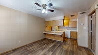 Located at 170 Cedar Creek Ct in Van Buren, Arkansas, this single-floor, one-bedroom, one-bathroom unit offers a practical and well-organized layout. The open living and kitchen area is anchored by durable wood-look flooring and a ceiling fan with light fixture, creating a comfortable and functional common space. The kitchen is a standout feature, equipped with warm honey-toned wood cabinetry extending to the upper walls, white appliances including a coil cooktop range, refrigerator, and dishwasher, plus a double-basin sink. A peninsula countertop with overhang provides additional prep space and casual seating, making the kitchen both efficient and social. The bedroom offers a cozy retreat with plush wall-to-wall carpeting, neutral-toned walls, a window allowing natural light, and a built-in closet with a hanging rod for organized storage. The bathroom includes a single-sink vanity with wood cabinetry, a full tub and shower combination, and matching wood-look flooring that ties the space together visually. Throughout the unit, a consistent neutral color palette and practical finishes contribute to a clean, move-in-ready ambiance suited for comfortable everyday living.
