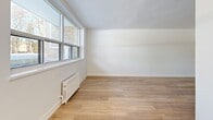 Located at 29-31 Upper Canada Dr in Toronto's desirable North York neighbourhood, this well-appointed 2-bedroom, 1-bathroom unit offers a thoughtfully updated interior across a single floor. The layout flows comfortably through multiple living areas, all finished with warm, light-toned hardwood flooring and crisp white walls that create a bright, cohesive aesthetic throughout.

The kitchen features white shaker-style cabinetry, a subway tile backsplash, a built-in electric range, and a stainless-accented sink — combining clean design with practical functionality. Adjacent living spaces are generously proportioned, with large windows that invite natural light and offer views of mature trees outside.

Both bedrooms are well-sized, each equipped with sliding double-door closets for ample storage. The primary bedroom provides a comfortable footprint with a window overlooking the greenery beyond. Radiator heating is present throughout, offering consistent warmth.

The bathroom is finished with marble-look wall tiling surrounding a full soaker tub and shower, complemented by a white vanity with brushed gold hardware and a mirrored medicine cabinet. The overall presentation is clean, modern, and move-in ready, making this unit a practical and attractive option in a well-established Toronto location.