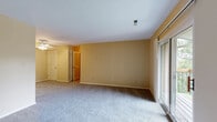 This single-floor residence offers a thoughtfully laid-out floor plan accommodating six bedrooms, one full bathroom, a utility room, a dedicated laundry area, and a closet. The interior is finished with soft wall-to-wall carpeting throughout, complemented by warm neutral-toned walls that create a cohesive and inviting atmosphere across all rooms.

The generously sized primary bedroom stands out as a particularly spacious retreat, featuring a large walk-in closet equipped with multi-tiered wire shelving for ample storage. A sliding mirrored closet door is featured in one of the additional bedrooms, further maximizing storage efficiency. Several bedrooms are fitted with ceiling fans with integrated lighting, enhancing both comfort and functionality. Multiple bedrooms benefit from natural light through windows with views of surrounding greenery, lending a bright, airy feel to the space.

The full bathroom is finished with clean white tile surrounding a full-length soaking tub and shower combination, accented by brushed nickel fixtures. The dedicated laundry room and utility space add everyday practicality to the layout. The 3D floorplan reveals a well-organized and efficiently designed residence, with a kitchen area and access to an outdoor space visible through a glass door. Clean white ceilings and consistent trim work throughout tie the entire space together cohesively.