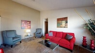 This single-story, 1-bedroom, 1-bathroom unit in Little Rock, Arkansas, offers a well-organized layout designed to maximize functionality. The living room serves as the central gathering space, featuring notable vaulted ceilings that lend a sense of openness beyond the unit's footprint. Plush carpeting runs throughout, and natural light filters in through blinds-covered windows near the front entry door, brightening the space. The galley-style kitchen is efficiently arranged, featuring dark wood cabinetry, a white appliance suite including a refrigerator, electric range, and dishwasher, along with hardwood-style flooring and a ventilation hood above the stove. A dedicated dining area adjacent to the kitchen benefits from additional natural light through a large window and is illuminated overhead by a pendant light fixture. A stacked in-unit washer and dryer is conveniently housed within the kitchen corridor. The bedroom is comfortably sized, finished with carpet, a ceiling fan with integrated lighting, and a window providing natural light. The bathroom features a vanity with a framed mirror, overhead cabinetry for storage, and a shower-tub combination. Overall, the unit offers a practical, comfortable living environment.