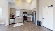 Located at 1769 E Walnut St in Pasadena, California, this modern single-story unit showcases a thoughtfully designed open layout with contemporary finishes throughout. The kitchen is a standout feature, boasting soaring ceilings, light wood cabinetry, a mosaic tile backsplash, white quartz countertops, and a full suite of stainless steel appliances including a gas range, built-in microwave, dishwasher, and French door refrigerator. Wood-look flooring runs throughout the main living areas, lending warmth and continuity to the space. The open-concept design connects the kitchen seamlessly to the dining area, which is bathed in natural light from large windows and French doors that open to the outdoors. A dedicated hallway leads to the bedroom, which features plush carpeting, neutral tones, and a generously sized window that fills the room with soft, natural light. A conveniently located in-unit laundry closet with a stacked washer and dryer adds practical functionality. Throughout the unit, high ceilings and neutral wall tones create a bright, airy ambiance, while the clean, modern aesthetic makes for a polished and move-in-ready living environment.