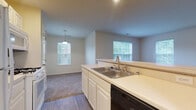 Located at 6345 Cooper Rd in Columbus, Ohio, this single-floor home offers a practical and comfortable layout designed for everyday living. The kitchen is a functional centerpiece, featuring white cabinetry, light countertops, a double stainless steel sink, a dishwasher, a gas range, and a full-size refrigerator. Wood-style flooring runs through the kitchen, which opens via a peninsula into a bright dining area illuminated by a pendant light and natural light from multiple windows. The adjacent living room is generously sized, with plush carpeting and large windows that invite an abundance of natural light and views of the surrounding greenery, creating a warm and welcoming atmosphere. The bedrooms are well-proportioned, outfitted with soft carpeting and featuring panel-style closet doors for ample storage. At least one bedroom benefits from a dedicated window, enhancing its airy feel. The bathroom is clean and neatly appointed with white cabinetry, a single vanity, a toilet, and a full tub-shower combination, with wood-style flooring tying the space together. Throughout the home, neutral tones and crown molding details contribute to a cohesive, move-in-ready aesthetic.