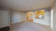 This single-floor, 2-bedroom, 2-bathroom residence in Houston, TX offers a thoughtfully designed layout that balances comfort and functionality. The spacious living area features plush wall-to-wall carpeting, neutral gray walls, and elegant crown molding that carries throughout the home, creating a cohesive and polished aesthetic. A graceful arched passageway connects the living room to the dining area, adding an architectural charm to the open floor plan. Natural light filters in through sizable windows fitted with blinds, enhancing the bright and airy atmosphere.

The kitchen is well-equipped with warm honey-toned cabinetry, dark granite-style countertops, hardwood-style flooring, and a full suite of white appliances including a refrigerator, range, and microwave. A peninsula with a sink provides a convenient workspace and casual dining option, complemented by pendant lighting overhead.

Both bedrooms are generously sized with soft carpeting, crown molding, and ceiling fans for year-round comfort. Each room offers ample natural light through large windows. The two full bathrooms feature light wood cabinetry, dark countertops, hardwood-style flooring, and tub-shower combinations, providing a clean and functional design. The overall ambiance of this home is calm, neutral, and move-in ready.