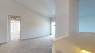This single-floor residence offers a well-organized layout with a variety of functional spaces. The living room serves as a central gathering area, highlighted by soaring vaulted ceilings fitted with a ceiling fan and a striking floor-to-ceiling tiled fireplace surround. Soft carpeting runs throughout the living areas and bedrooms, contributing to a warm, comfortable ambiance. Natural light filters in through vertical blinds and windows, brightening the neutral white walls throughout.

The galley-style kitchen is efficiently designed with white cabinetry, rich granite-tone countertops, tile flooring, and stainless steel appliances including a refrigerator and dishwasher. A dedicated utility closet adjacent to the kitchen conveniently houses an in-unit washer and dryer.

The bedrooms are generously proportioned, carpeted, and well-lit by natural light from windows with views to the outdoors. Two bathrooms serve the home: one features a sliding glass-door shower stall, while the other includes a soaking tub and shower combination. Both bathrooms are finished with granite-topped white vanities, large mirrors, and warm tile flooring, providing a cohesive and polished aesthetic throughout.