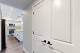 Located at 305 Timberland Drive in Ann Arbor, Michigan, this well-designed single-story home offers three bedrooms, two bathrooms, and a thoughtfully laid-out floor plan. The interior is finished with a clean, contemporary aesthetic featuring neutral tones, crisp white trim, and durable wood-look flooring throughout the main living areas.

The kitchen is a standout space, showcasing white shaker-style cabinetry with matte black hardware, granite countertops, stainless steel appliances, and a central island with pendant lighting — ideal for both cooking and entertaining. The open connection to the living area enhances the sense of space and flow.

The primary bedroom is generously sized and features plush carpeting, while its en-suite bathroom is appointed with a glass-enclosed walk-in shower, granite vanity, and matte black fixtures. A dedicated walk-in closet with built-in shelving provides ample storage. The secondary bathroom includes a shower-tub combination and a matching granite vanity with shaker cabinetry.

The additional bedrooms offer comfortable dimensions, with one featuring natural light from a window overlooking a green outdoor view. Hallways connect the spaces efficiently, and a utility room adds practical functionality. The home presents a move-in-ready, modern living experience throughout.