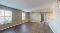 Located at 850 Wilkinson Trace in Bowling Green, Kentucky, this single-floor home offers a well-designed layout with a consistent, modern aesthetic throughout. The living areas feature rich, dark hardwood-style flooring and neutral warm-gray walls, creating a clean and inviting atmosphere. Ceiling fans are present in the main living and bedroom areas, adding both function and style. Natural light filters in through multiple windows fitted with blinds across the home.

The galley-style kitchen is efficiently laid out with two-tone cabinetry — white upper cabinets paired with darker lower cabinets — granite countertops, a stainless steel sink, and stainless steel appliances including a refrigerator and range. Overhead lighting keeps the kitchen bright and functional.

The bedrooms feature plush carpeting, ample natural light from large windows, and generous closet space, including a walk-in closet in one room. The bathroom is well-appointed with a double-sink vanity topped with granite countertops, dark navy-blue cabinetry, dual mirrors, and a combination tub and shower. Dark hardwood-style flooring continues into the bathroom, tying the design together cohesively. The overall layout is practical and thoughtfully finished, offering comfortable, move-in-ready living.