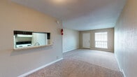 This single-story, 2-bedroom, 1.5-bathroom residence is thoughtfully organized for practical, everyday living. The open living area serves as the central hub of the home, featuring neutral-toned carpet, textured ceilings, and warm beige walls that create a welcoming atmosphere. A large window near the front entry allows natural light to fill the space, enhancing its open feel. A pass-through window connects the living area to the kitchen, promoting an open sightline between the two spaces.

The kitchen is laid out in a galley style, equipped with dark espresso cabinetry, light stone-look countertops, a double sink, and white appliances including a range and refrigerator. Tile-style flooring runs throughout the kitchen, providing easy maintenance.

Both bedrooms are generously proportioned and carpeted, with large windows that bring in natural light and views of the surroundings. One bedroom features a ceiling fan for added comfort. Each bedroom benefits from proximity to the bathrooms, both of which include dark wood vanities with light countertops, framed mirrors, and tile flooring. The full bathroom includes a tub-shower combination with tiled surround.