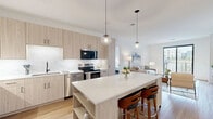 Located at 95 Yorktown Shopping Center in Lombard, IL, this well-appointed 3-bedroom, 2-bathroom residence offers a thoughtfully designed single-floor layout with modern finishes throughout. The open-concept living and kitchen area serves as the heart of the home, with light hardwood flooring, crisp white walls, and an abundance of natural light. The living room features large sliding glass doors that open to a private balcony, providing views of the surrounding neighborhood. The contemporary kitchen is a standout, outfitted with light wood cabinetry, white quartz countertops, a marble-look backsplash, stainless steel appliances, and a central island with pendant lighting — ideal for both everyday cooking and entertaining. The spacious primary bedroom offers plush carpeting and generous proportions, complemented by a well-organized walk-in closet with built-in shelving and hanging rods. Two additional bedrooms provide versatile space, each finished with soft carpeting and clean, neutral walls. Both bathrooms are sleekly designed, featuring glass-enclosed walk-in showers with large-format marble-style tile and matte black hardware accents. Two dedicated closets add practical storage throughout. The overall ambiance is bright, clean, and modern.