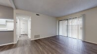 Located at 1251 Massachusetts Ave in Riverside, California, this single-floor residence offers a well-organized layout with a clean, modern aesthetic. Throughout the unit, wood-style plank flooring adds warmth and continuity, complemented by crisp white walls and textured ceilings with integrated HVAC vents for year-round comfort.

The living area is bright and open, anchored by a full-width sliding glass door dressed with vertical blinds, allowing generous natural light and outdoor access. The space flows seamlessly into the dining area, which connects directly to the kitchen. The kitchen features a peninsula-style counter with a light stone surface, an undermount double sink with a brushed nickel pull-down faucet, white cabinetry, and a gas range — providing both functionality and a contemporary look.

The bedroom is comfortably proportioned with a large window that brings in natural light and a double sliding-door closet offering ample storage. The bathroom is finished with a white vanity, speckled stone countertop, undermount sink, brushed nickel fixtures, and a well-lit mirror — all maintaining the unit's cohesive, neutral palette.

Overall, the space presents a tidy, move-in-ready environment with consistent finishes and practical design throughout.