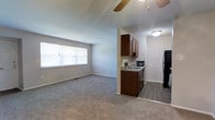 Located at 500 Chews Landing Road in Lindenwold, New Jersey, this single-floor unit offers a functional and comfortable layout designed for everyday living. The open-concept living area is finished with plush wall-to-wall carpeting that adds warmth underfoot, while neutral-toned walls create a clean, versatile backdrop throughout. A ceiling fan overhead provides both comfort and airflow, complementing the natural light that pours in through a large window, brightening the space throughout the day. The living area flows seamlessly into the kitchen, which is defined by rich dark wood cabinetry that provides ample storage. The kitchen is equipped with a sink set into a countertop, a black refrigerator, and a dishwasher, making it a practical and well-appointed space for cooking and meal preparation. The transition from carpeted living space to hard-surface kitchen flooring creates a clear and attractive visual separation between areas. The overall layout is efficient and thoughtfully arranged, offering a welcoming ambiance that balances comfort with practicality. This unit is well-suited for those seeking a low-maintenance, move-in-ready home in the Lindenwold area of southern New Jersey.