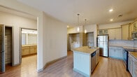 Located at 1001 Quarters Landing Cir in Sneads Ferry, NC, this single-floor residence offers a well-designed, functional layout with contemporary finishes throughout. The kitchen serves as a central highlight, featuring granite countertops, a central island with a built-in sink and dishwasher, gray shaker-style cabinetry, a white subway tile backsplash, and a full suite of stainless steel appliances including a refrigerator, range, and microwave. Pendant lighting above the island adds a modern touch, while light wood-look flooring flows throughout the main living areas. An in-unit laundry area with a washer and dryer is conveniently accessible from the kitchen. The living spaces benefit from ceiling fans and access to an outdoor area via a glass-paneled door that brings in natural light. The bedrooms are carpeted for comfort and equipped with ceiling fans, with one bedroom featuring a walk-in closet and direct access to the bathroom. The bathroom includes a soaking tub with a tiled surround and brushed nickel fixtures. Neutral wall tones and clean lines throughout contribute to a bright, move-in-ready atmosphere ideal for comfortable everyday living.