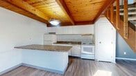 This 750 square foot townhouse in Columbus, Ohio offers a compact yet functional living space across two floors. The property features two bedrooms, including a primary bedroom of 150 square feet, and one bathroom. The kitchen is a highlight, boasting white cabinetry, granite countertops, and modern appliances. An island provides additional counter space and separates the kitchen from the living area.

The home's design incorporates a mix of flooring types, with hardwood in the main living areas and carpet in the bedrooms. A standout architectural element is the wood-paneled ceiling in some rooms, adding warmth and character to the space. Large windows and sliding glass doors allow ample natural light to flood the interiors.

The living room features a ceiling fan for comfort, while the bathroom includes a standard tub-shower combination. Storage space is available through a closet, and the property includes two staircases for easy navigation between floors. The overall aesthetic is clean and modern, with neutral tones throughout, making it an ideal canvas for personalization. This townhouse would suit small families or young professionals looking for a low-maintenance yet stylish living space in Columbus.