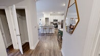 Located at 875 Cornerstone Dr in Knoxville, Tennessee, this single-story residence offers two bedrooms and two bathrooms within a thoughtfully designed open-concept floor plan. Wood-style luxury vinyl plank flooring flows through the main living areas, creating a cohesive and contemporary aesthetic.

The kitchen serves as a central hub, featuring white shaker cabinetry extending to the ceiling, stainless steel appliances including a range, microwave, and refrigerator, subway tile backsplash, and a peninsula with an undermount sink and bar seating. The adjacent dining area provides a defined space for meals, while the living room offers access to an outdoor area through glass French doors, complemented by a ceiling fan.

Both bedrooms are carpeted and equipped with ceiling fans and natural light from large windows. The primary bedroom includes a walk-in closet with wire shelving systems. The bathrooms mirror each other in finish quality, featuring white vanities with light countertops, large mirrors, and tub-shower combinations with wood-style flooring. A dedicated laundry area houses a full-size washer and dryer with overhead wire shelving for additional storage.