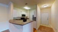 Located at 923 Slateworth Dr in Durham, NC, this single-floor residence offers a well-organized layout designed for comfortable everyday living. The kitchen serves as a practical hub of the home, featuring white cabinetry with ample storage, dark granite-style countertops, stainless steel appliances including a range, microwave, and refrigerator, and a double basin sink. A peninsula counter provides additional workspace and creates a natural transition toward the adjoining living areas. Hardwood-style flooring runs through the kitchen, adding warmth and durability to the space.

The living area is generously proportioned, featuring neutral carpet, crown molding, a ceiling fan with light fixture, and vertical blinds that allow for natural light control. The layout flows seamlessly from the entry toward additional rooms, offering a connected and airy feel throughout.

The bedrooms are carpeted and bathed in natural light from large windows with exterior views of the surrounding neighborhood. Each room includes a ceiling fan, providing both comfort and ventilation.

The bathroom is well-appointed with a long dual-sink vanity topped with granite-style countertops, white cabinetry below, a large framed mirror, and a tiled tub-shower combination featuring a checkered tile accent pattern. The overall aesthetic throughout the home is clean, neutral, and move-in ready.