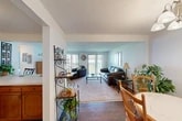 Located at 417 N Levitt St in Rome, NY, this two-bedroom, one-bathroom residence offers a well-organized single-floor layout with a comfortable and functional design throughout. The living room serves as the heart of the home, featuring large sliding glass doors that fill the space with natural light and provide direct access to a private balcony with outdoor views. The open sightlines between the living and dining areas create a welcoming, connected feel. The dining room includes rich hardwood-style flooring, a chandelier overhead, and a closet, adding a practical touch near the entryway. The kitchen is well-appointed with warm wood cabinetry, white countertops, white appliances including a dishwasher and refrigerator, and light tile flooring — offering ample storage and workspace. The primary bedroom is generously sized with carpeted flooring, a large window with vertical blinds, and room for substantial furniture. The second bedroom is bright and cozy, also carpeted, with a large window overlooking greenery. The full bathroom provides a tub/shower combination. Three closets throughout the residence ensure plentiful storage. The overall palette of soft blues, whites, and warm wood tones creates a calm and inviting atmosphere.