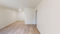 Located at 3975 Seven Trees Blvd in San Jose, CA, this one-bedroom, one-bathroom unit offers a functional and efficient single-floor layout. Wood-style plank flooring runs throughout the space, creating a cohesive and clean aesthetic. The galley-style kitchen features white cabinetry, marble-look countertops, a stainless steel sink, and white appliances including a coil-top range and refrigerator, all accented by ample overhead cabinet storage. Adjacent to the kitchen, the combined living and dining area provides an open, versatile space filled with natural light from a large window overlooking lush greenery. A wall-mounted air conditioning unit and baseboard heating ensure year-round comfort. The bedroom is a well-proportioned room with a window that brings in natural light, complemented by wood-style flooring and a dedicated closet with dual shelving for organized storage. The bathroom is outfitted with a full tub-shower combination, a vanity, and wood-style flooring, maintaining the consistent design language found throughout the unit. Neutral warm-white walls across all rooms contribute to a bright, airy ambiance that makes the space feel welcoming and easy to personalize.