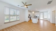 Located at 4980 Red Maple Ln in Wildwood, Florida, this two-story home offers a thoughtfully designed layout spread across two floors. The main level hosts the majority of the living space, featuring an open-concept kitchen and living room filled with natural light from multiple windows. The kitchen is outfitted with crisp white cabinetry, granite countertops, a center island, and stainless steel appliances including a refrigerator with ice maker, electric range, and microwave. Light wood-style flooring runs throughout the main level, complemented by ceiling fans that enhance the airy atmosphere. A staircase leads to the upper level, where plush carpeted bedrooms provide a comfortable retreat. The generously sized primary bedroom includes a walk-in closet and an en-suite bathroom featuring a double granite-topped vanity and a glass-enclosed walk-in shower with subway tile surround. Additional bathrooms are equally well-finished, with granite vanities, subway tile tub-shower combos, and wood-style flooring. Two closets offer ample storage throughout. A dedicated laundry room with a full-size washer and dryer adds everyday convenience. With three bedrooms, three full bathrooms, and a practical two-floor layout, this home delivers a comfortable and functional living experience.