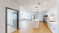 Located in Olathe, KS, this thoughtfully designed 2-bedroom, 3-bathroom single-story home offers a contemporary open-concept layout with high-quality finishes throughout. The heart of the home is a bright, open living and kitchen area featuring warm light wood flooring, crisp white walls, and a striking sculptural pendant light. The kitchen is well-appointed with white shaker cabinetry, a herringbone tile backsplash, quartz countertops, a large center island, and a full suite of stainless steel appliances. A separate dining area is highlighted by a modern gold and black chandelier and a natural light-filled window. The living room flows seamlessly from the kitchen, providing a generous, airy common space. Both bedrooms are carpeted and comfortable, with ceiling fans and dedicated closets featuring built-in shelving. The spacious primary bedroom offers a walk-in closet and ample room to accommodate a full furniture arrangement. The bathrooms are elegantly finished with large-format marble-look tile, a soaking tub with a frameless glass sliding door, backlit vanity mirrors, and white cabinetry with brushed nickel hardware. The cohesive design palette of white, gray, and warm wood tones creates a clean and modern ambiance throughout.