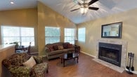 Located at 330 Cross Park Dr in Pearl, Mississippi, this single-floor residence offers a well-organized layout designed for comfortable everyday living. The living room is a standout space, featuring soaring vaulted ceilings, warm hardwood-style flooring, and a ceiling fan that enhances the airy feel. Multiple windows allow generous natural light to fill the room, while a tile-surround fireplace serves as an elegant focal point, adding warmth and character to the space. The kitchen is efficiently designed with white cabinetry accented by wood trim, white appliances including a range, built-in microwave, refrigerator, and dishwasher, along with a double-basin stainless steel sink and ample counter space. The bedrooms are carpeted for comfort, offering a quiet retreat with natural light from well-placed windows and generous wall space. The bathroom features a wide vanity with a large mirror, bright overhead lighting, a tub-shower combination, and hardwood-style flooring. Throughout the home, warm neutral tones on the walls create a cohesive and inviting ambiance, making this a functional and welcoming single-floor residence in the Pearl, Mississippi area.